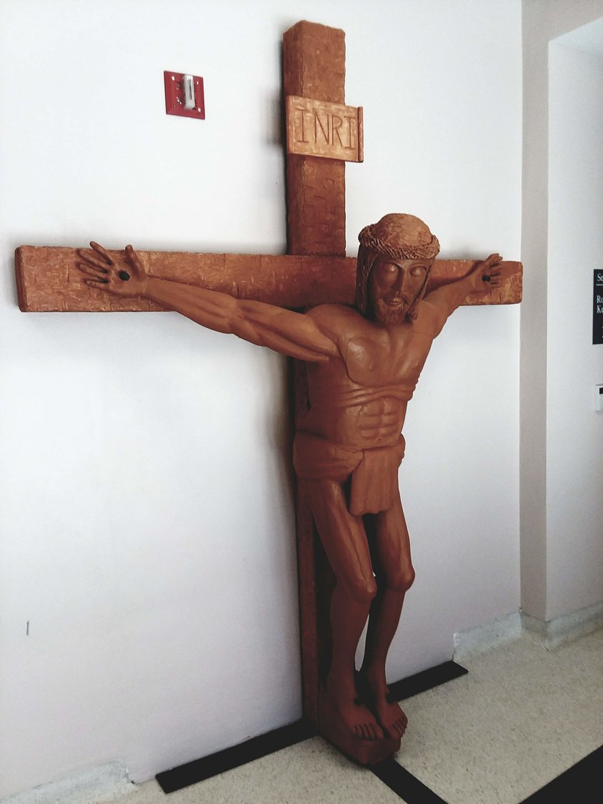 This carved wooden crucifix that adorns the student entrance to the St. Thomas More Newman Center in Columbia was made by Deacon Fred Weisel.