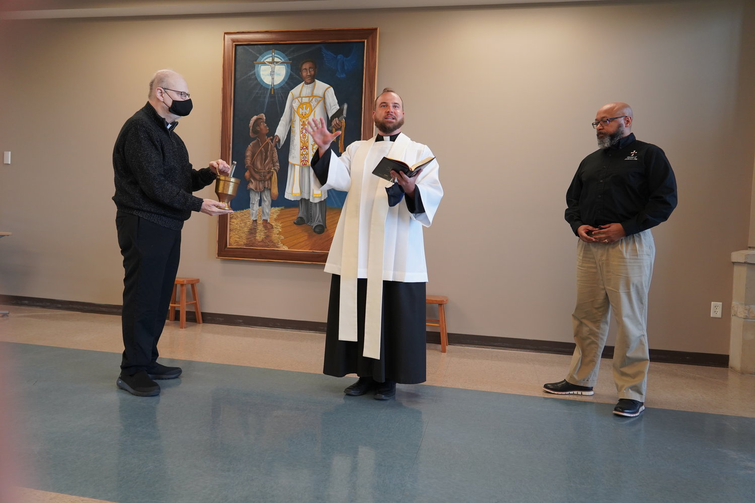 Father Michael Coleman, Father Paul Clark and Deacon William Seibert take part in the blessing and dedication of the new image of Venerable Father Augusus Tolton, titled “The Light that Guides the Faithful,” on May 14 at Fr. Tolton Regional Catholic High School in Columbia.